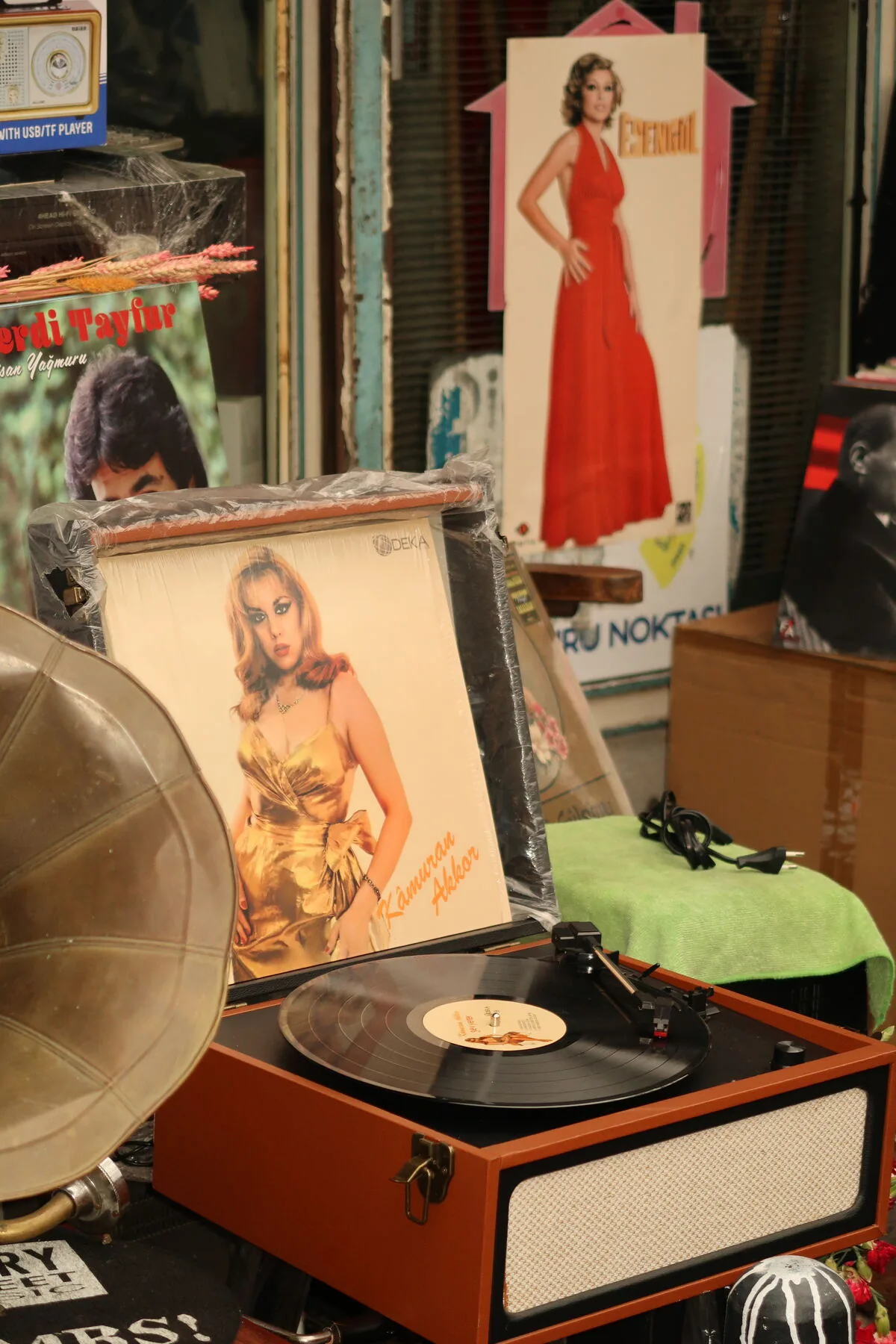 A market stall with a portable record player, a gramophone horn and printed sleeve art.