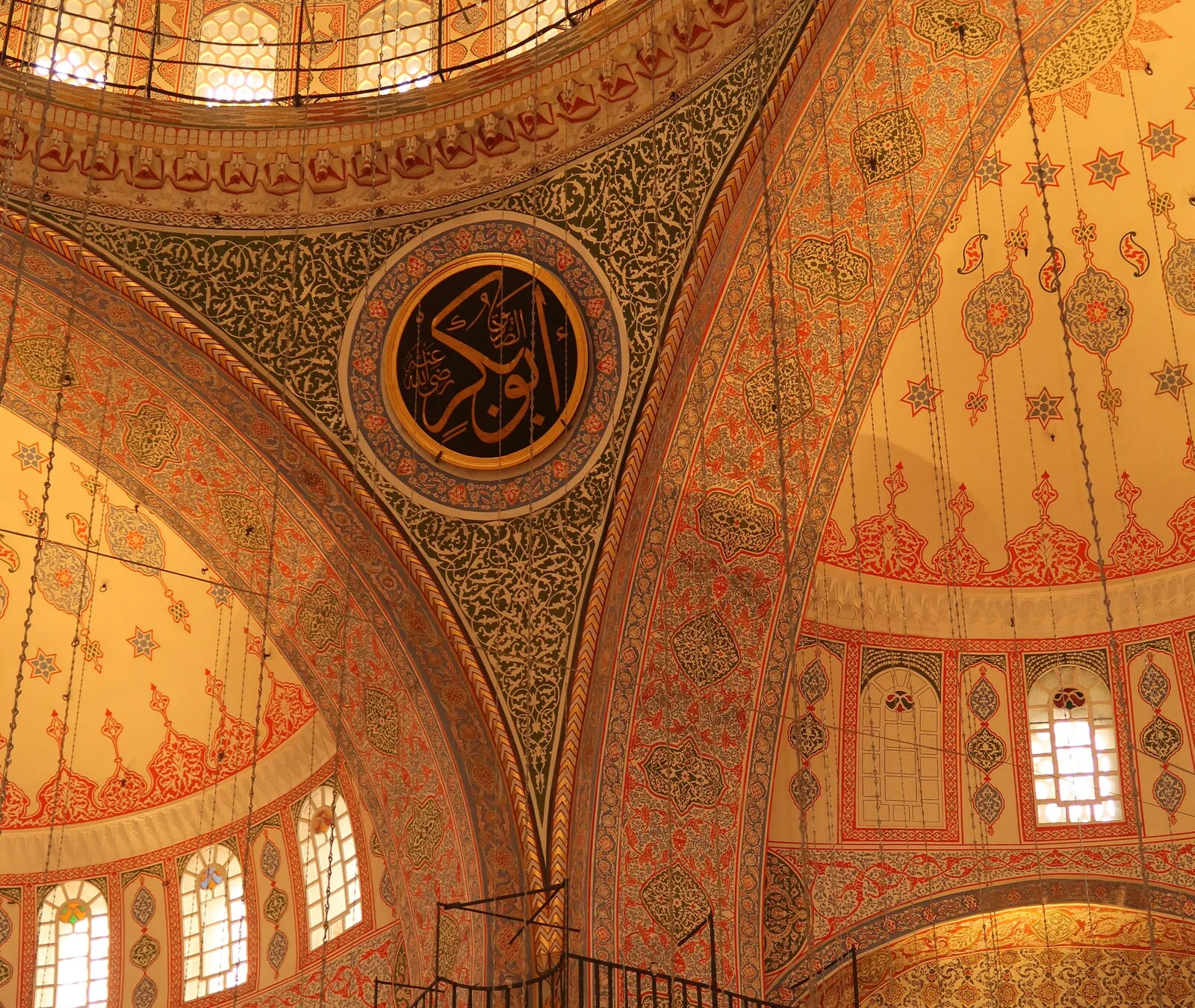 Hagia Sophia's painted domes and gilded roundels seen from the gallery, lit warm gold.